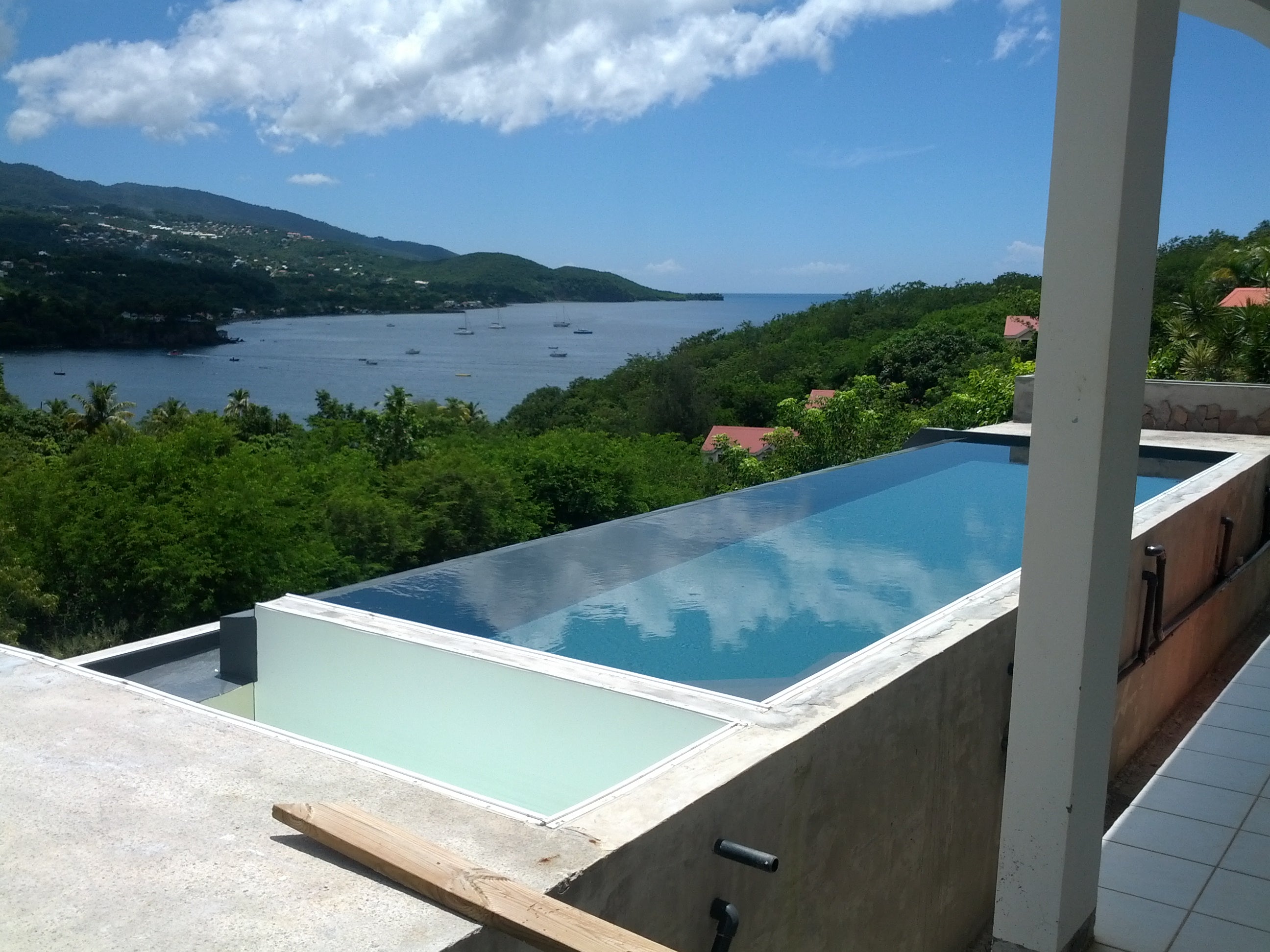 Construction Grande Piscine de Particulier en Guadeloupe, débordement, vue sur mer.